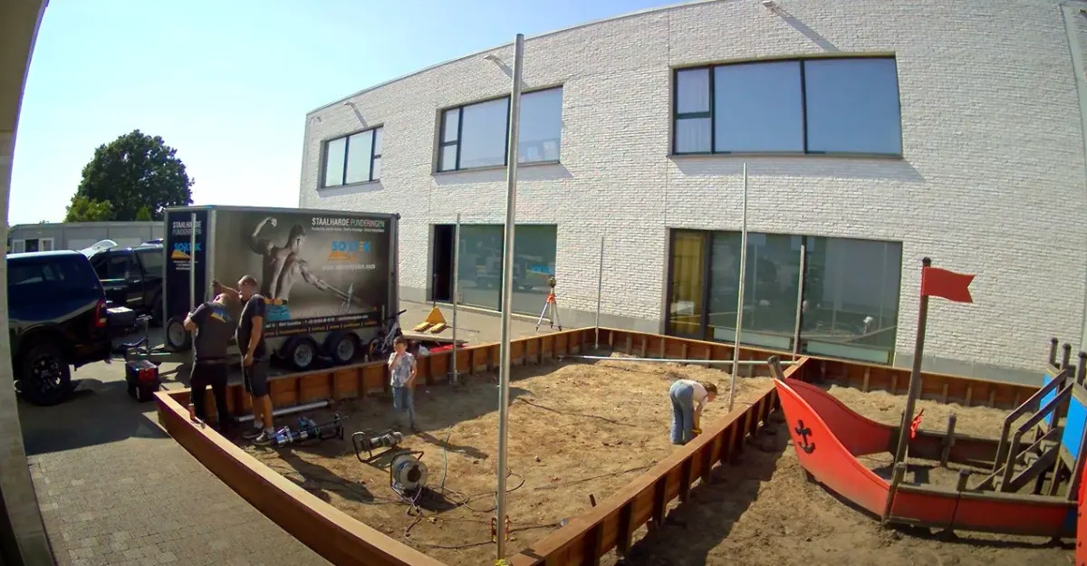 Zandbak van een school in Oostakker met schroefpalen voor een schaduwdoek